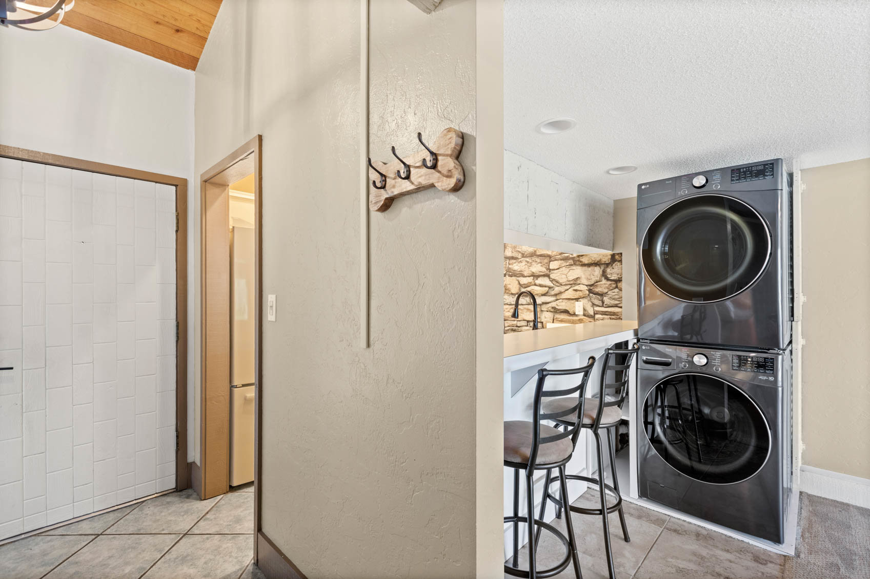 inside front door with entry to kitchen and stacked laundry machines